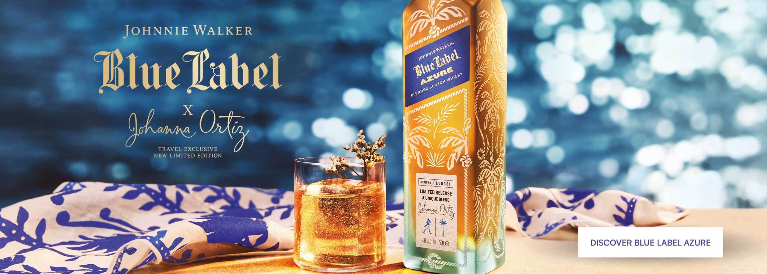 A bottle of Johnnie Walker Azure with a full glass, with the sea in the background.