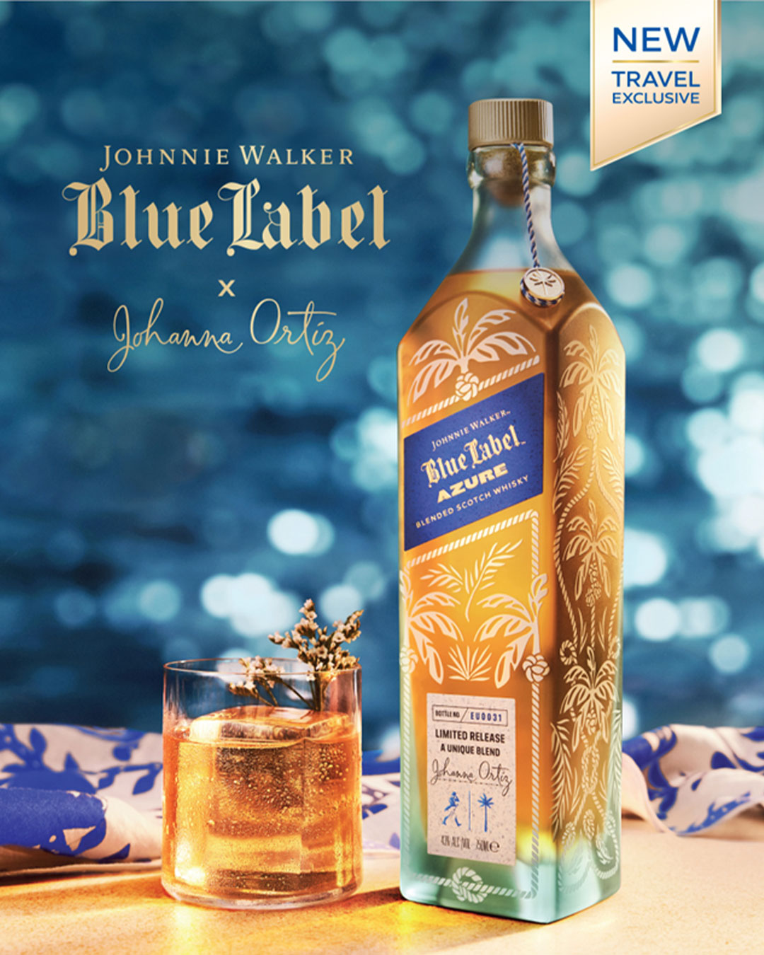 A bottle of Johnnie Walker Azure with a full glass, with the sea in the background.